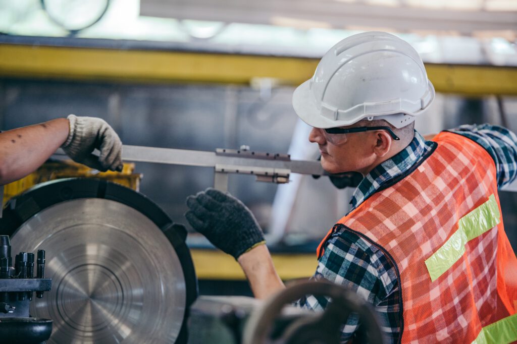 Engineer metalworker working on lathe machine